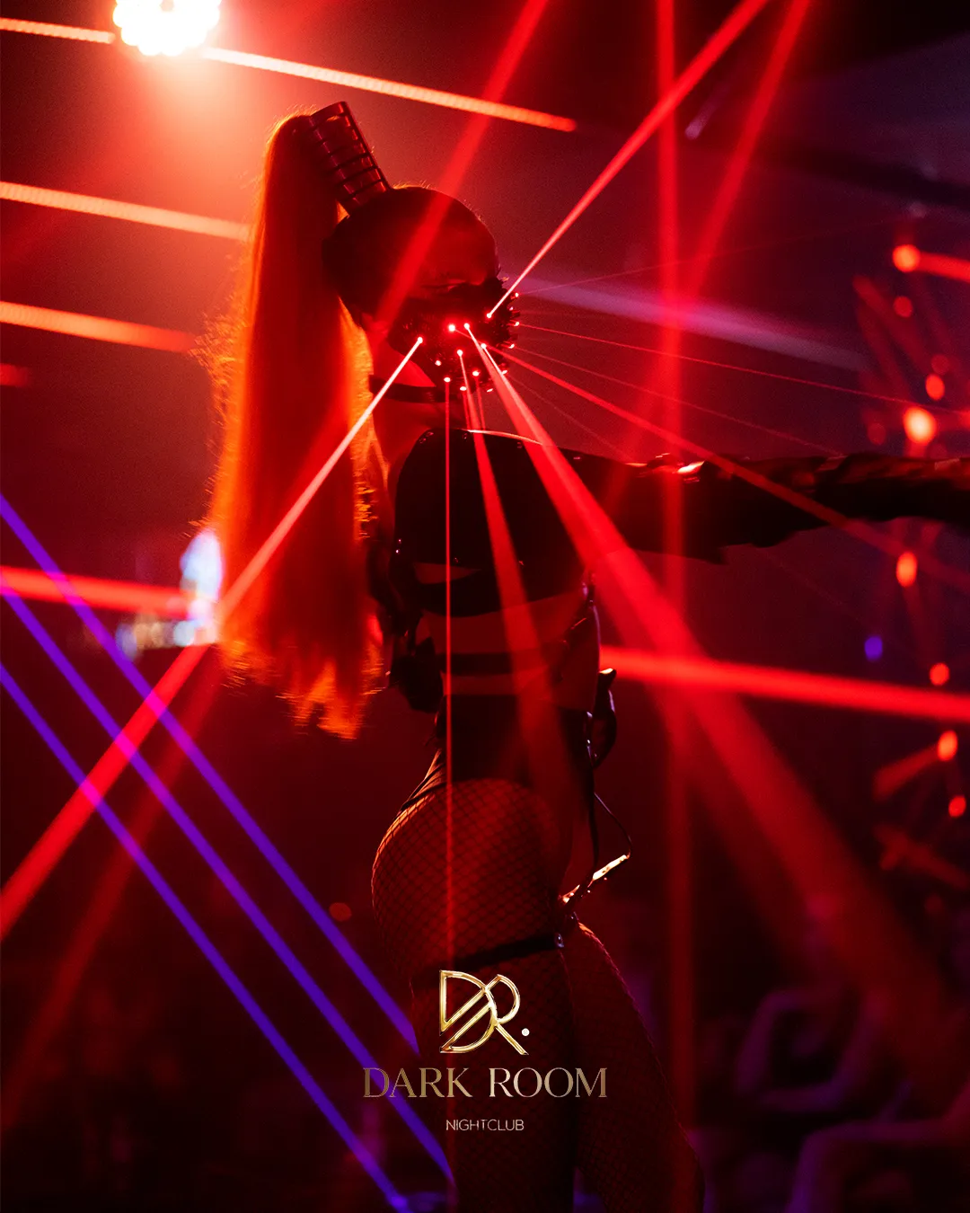 Performer with laser gloves under red lights on the dance floor